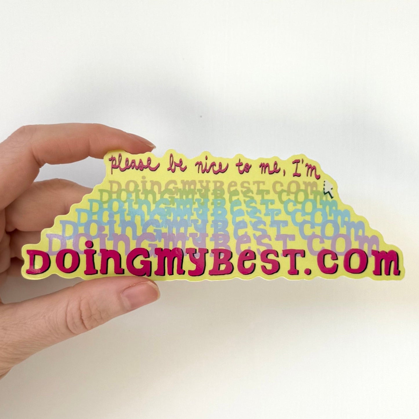 Hand holding a rainbow-colored sticker with text that says "doingmybest.com" on a white background